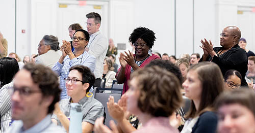 Attendees applauding and giving a standing ovation at the 2019 DLF Forum plenary